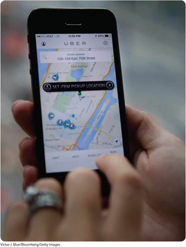A photo shows a person booking a cab with the Uber app through a smartphone.